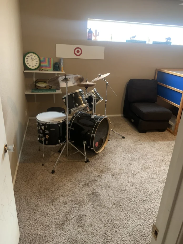 Bonus room with a drum set and chair after organizing