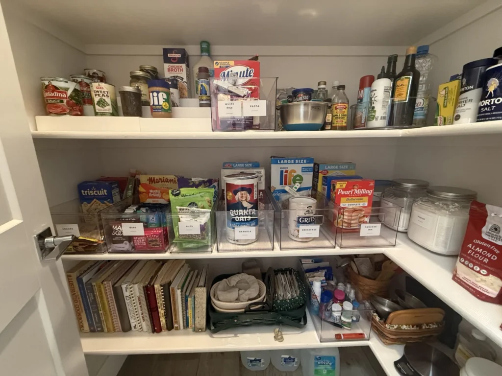 Pantry shelves with food grouped above and cookbooks below