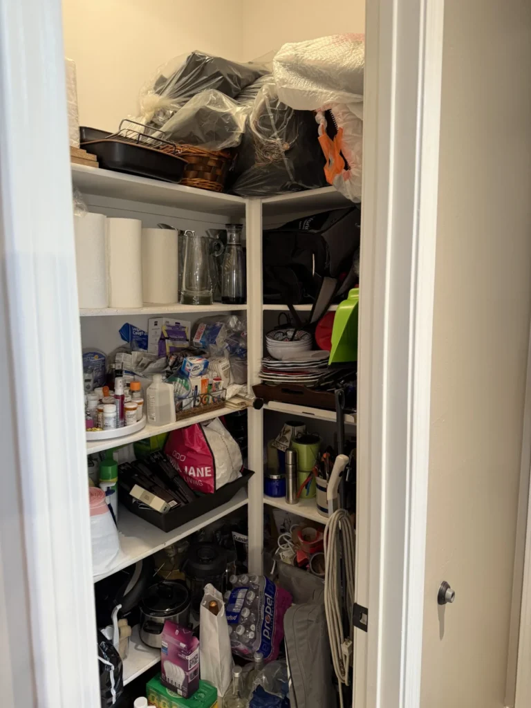 Storage closet before organizing, with bags piled on the shelves