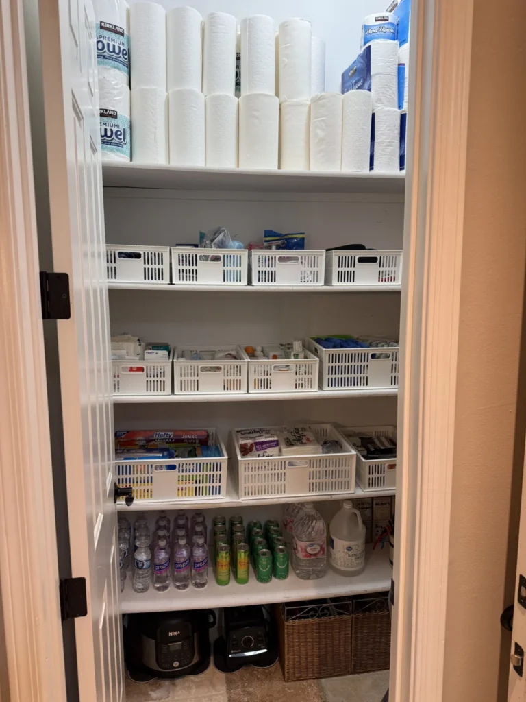 Linen and supply closet with labeled baskets on white shelves
