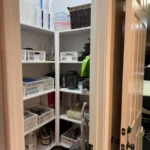 Supply closet with labeled bins, seen from the doorway