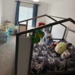 Child’s bedroom with a house-frame bed and toys on the bed