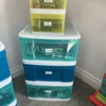 Stacked teal storage drawers with labels
