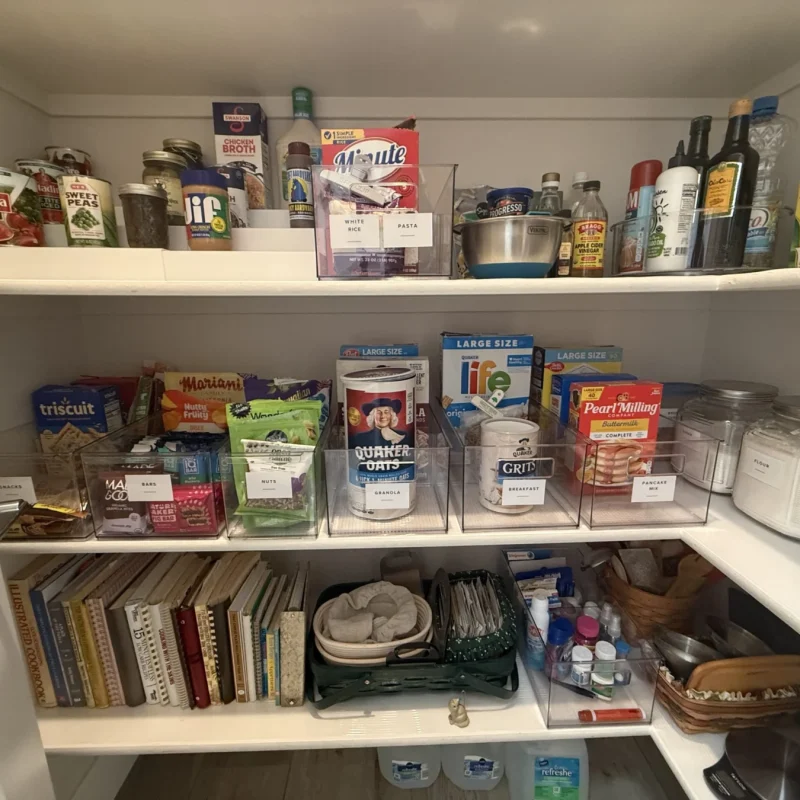 Pantry shelves with food grouped above and cookbooks below